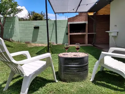 two white chairs and two glasses of wine at Casa Yowen in Mina Clavero
