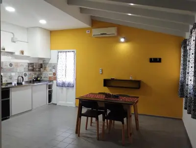 a kitchen with a table and a yellow wall at Casa Yowen in Mina Clavero