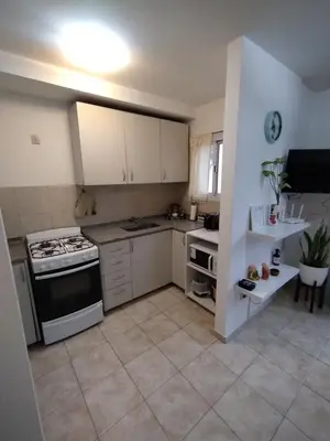 a kitchen with white cabinets and a stove top oven at Departamento Boutique in Cordoba
