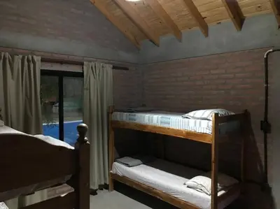 a bedroom with two bunk beds and a window at Cabaña CABEZA DE NIEVE Apta 6 personas in Carpintería