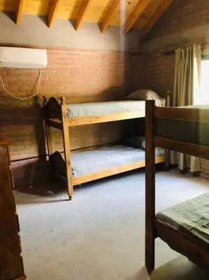 a bedroom with two bunk beds and a brick wall at Cabaña CABEZA DE NIEVE Apta 6 personas in Carpintería