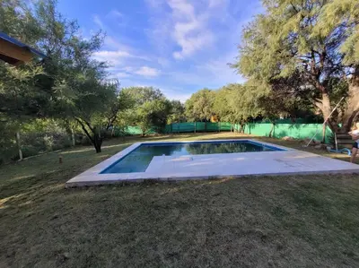 an empty swimming pool in a yard with trees at Cabaña CABEZA DE NIEVE Apta 6 personas in Carpintería