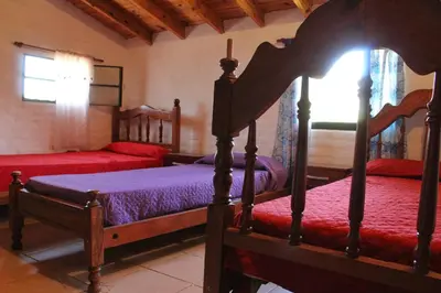 a bedroom with two beds with red sheets at Complejo Salamanca - Cabaña La Catalana in Trapiche