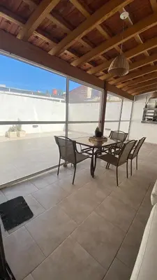 a dining room with a table and chairs on a patio at Departamento Edificio Manantiales in Villa Carlos Paz