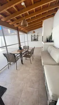 a living room with a table and chairs and a couch at Departamento Edificio Manantiales in Villa Carlos Paz