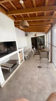 a living room with a fireplace and a table at Departamento Edificio Manantiales in Villa Carlos Paz