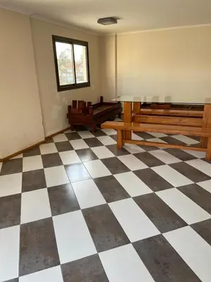an empty room with benches and a checkered floor at Departamento Edificio Manantiales in Villa Carlos Paz