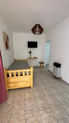 a bedroom with a bed and a flat screen tv at 760 D Apartamentos in Alta Gracia