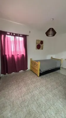 a bedroom with a bed and a window with red curtains at 760 D Apartamentos in Alta Gracia