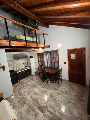 a kitchen with a wooden table and a kitchen with a dining room at Eurotrip in Mina Clavero