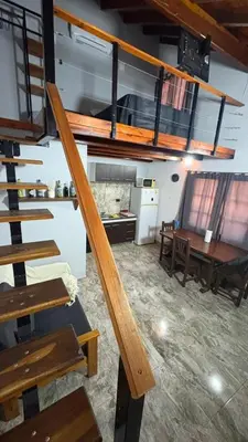 a staircase in a room with a kitchen and a table at Eurotrip in Mina Clavero