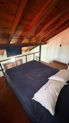 a large bed in a room with a wooden ceiling at Eurotrip in Mina Clavero