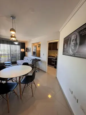 a living room with a table and chairs and a kitchen at Departamento en terra forte 1 in Cordoba