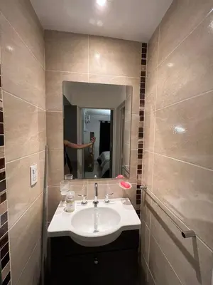 a bathroom with a sink and a person in the mirror at Departamento en terra forte 1 in Cordoba