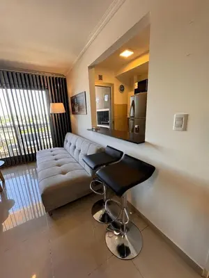 a living room with a couch and a bar stool at Departamento en terra forte 1 in Cordoba