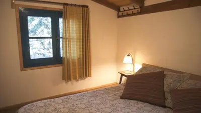 a bedroom with a bed and a window at Lila Cumbrecita in La Cumbrecita