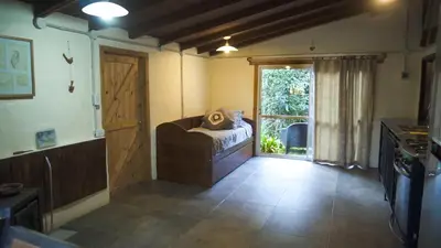 a room with a bed and a door with a window at Lila Cumbrecita in La Cumbrecita
