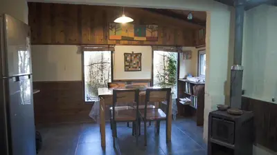 a dining room with a table and chairs in a house at Lila Cumbrecita in La Cumbrecita