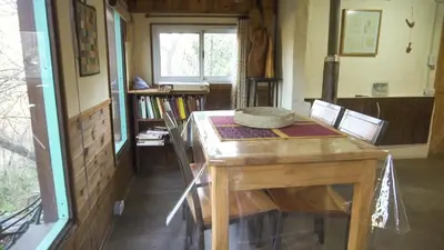a room with a wooden table and a window at Lila Cumbrecita in La Cumbrecita