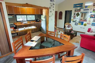 a kitchen with a table and a dining room at Hermosa casa con pileta para dos in Villa General Belgrano