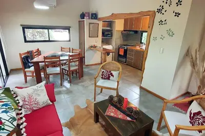 a living room with a table and a kitchen at Hermosa casa con pileta para dos in Villa General Belgrano