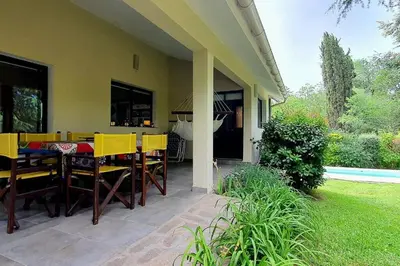 a patio with yellow chairs and a table on a house at Hermosa casa con pileta para dos in Villa General Belgrano