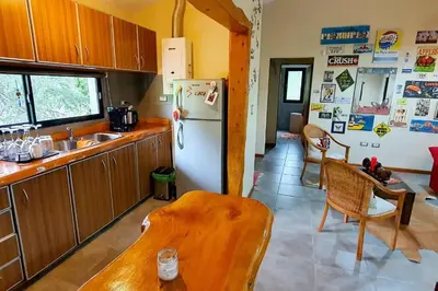 a kitchen with a refrigerator and a table in it at Hermosa casa con pileta para dos in Villa General Belgrano