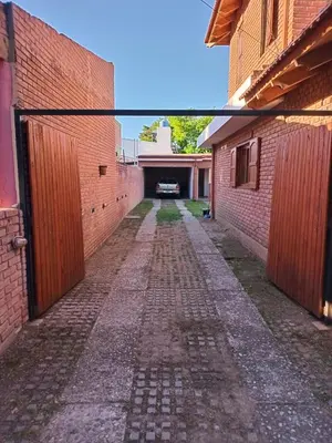 an alley way between two brick buildings with a gate at La casa de Yari in Mina Clavero