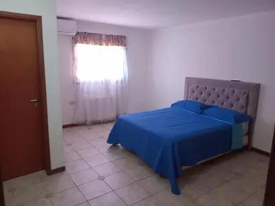 a bedroom with a blue bed and a window at La casa de Yari in Mina Clavero