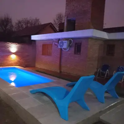a swimming pool in front of a house at night at La casa de Yari in Mina Clavero