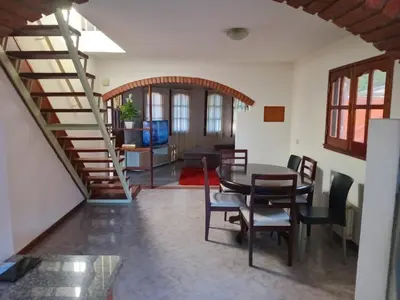 a living room with a table and chairs and a staircase at La casa de Yari in Mina Clavero
