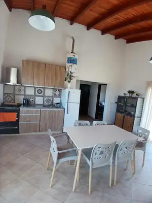 a kitchen with a white table and chairs at La Toscana in Villa Yacanto