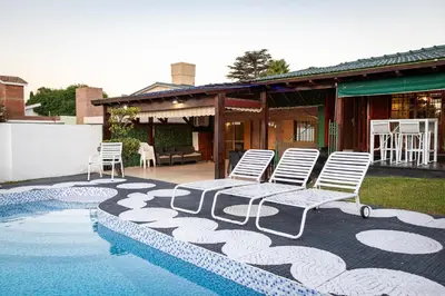 a couple of chairs sitting next to a swimming pool at Casa con pileta exclusiva a 3 cuadras de la costanera Villa Carlos Paz IG alquilervillacarlospaz in Villa Carlos Paz