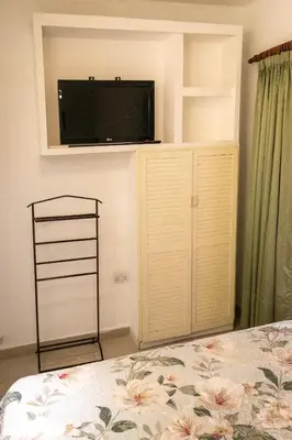 a bedroom with a bed and a tv on a wall at Casa con pileta exclusiva a 3 cuadras de la costanera Villa Carlos Paz IG alquilervillacarlospaz in Villa Carlos Paz