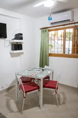 a table and chairs in a room with a window at Casa con pileta exclusiva a 3 cuadras de la costanera Villa Carlos Paz IG alquilervillacarlospaz in Villa Carlos Paz