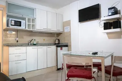 a kitchen with white cabinets and a table and chairs at Casa con pileta exclusiva a 3 cuadras de la costanera Villa Carlos Paz IG alquilervillacarlospaz in Villa Carlos Paz