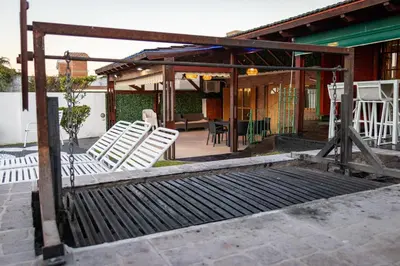 a group of white chairs sitting on a patio at Casa con pileta exclusiva a 3 cuadras de la costanera Villa Carlos Paz IG alquilervillacarlospaz in Villa Carlos Paz
