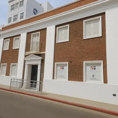 a brick building with white windows on a street at Atenea Residence in Cordoba