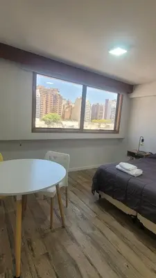 a room with a bed and a table and a window at MONOAMBIENTE VILAUT Temporario in Cordoba