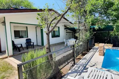 a house with a swimming pool and a fence at Chalet Céntrico con Pileta in Villa General Belgrano