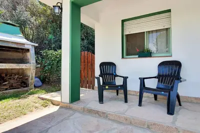 two black chairs sitting on a porch with a fireplace at Chalet Céntrico con Pileta in Villa General Belgrano
