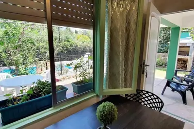 a room with a large window with a table and chairs at Chalet Céntrico con Pileta in Villa General Belgrano