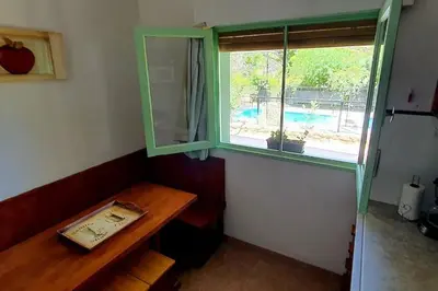 a window in a room with a wooden table and a table sidx sidx sidx at Chalet Céntrico con Pileta in Villa General Belgrano