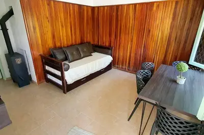 a bedroom with a bed and a wooden wall at Chalet Céntrico con Pileta in Villa General Belgrano