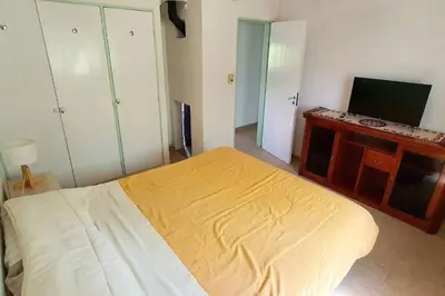 a bedroom with a bed and a flat screen tv at Chalet Céntrico con Pileta in Villa General Belgrano