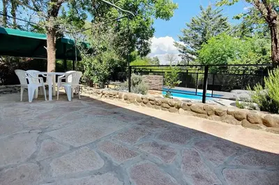 a patio with a table and chairs next to a pool at Chalet Céntrico con Pileta in Villa General Belgrano
