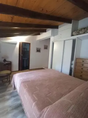 a bedroom with a large bed and a wooden ceiling at Casita en Villa General Belgrano in Villa General Belgrano