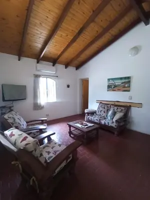 a living room with couches and a flat screen tv at Casita en Villa General Belgrano in Villa General Belgrano