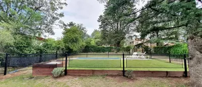 a tennis court in a yard with a tennis racket at Casita en Villa General Belgrano in Villa General Belgrano