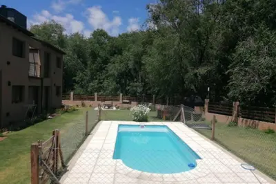 a swimming pool in a yard next to a house at Departamento con pileta y asadores in Villa General Belgrano